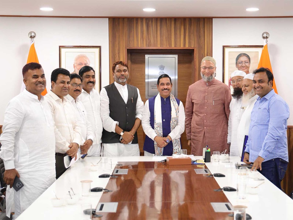 Pralhad Joshi standing at the centre of a group of visitors around a conference table