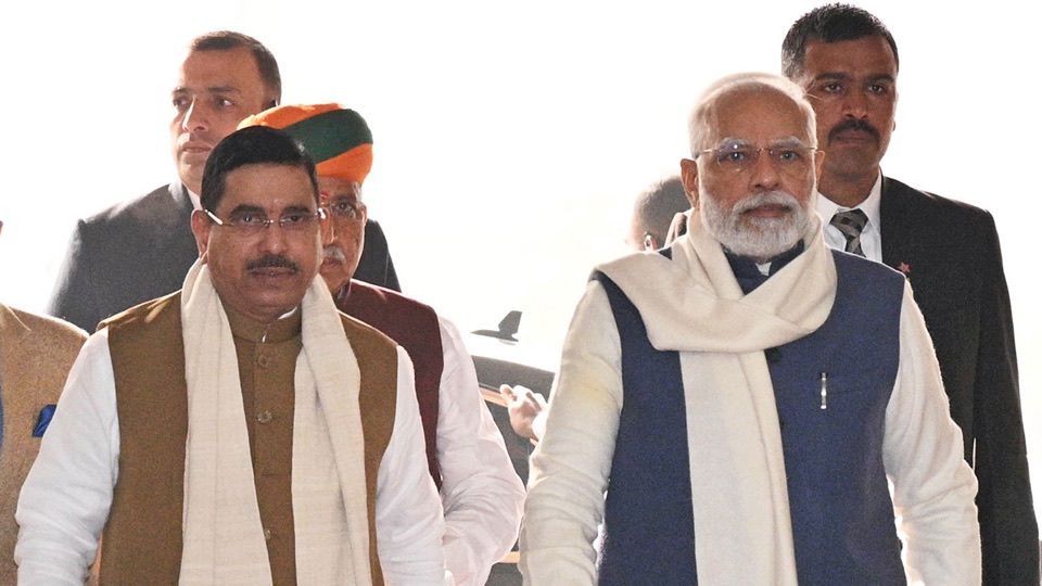 Pralhad Joshi walking alongside Prime Minister Narendra Modi, both wearing shawls, with others behind them